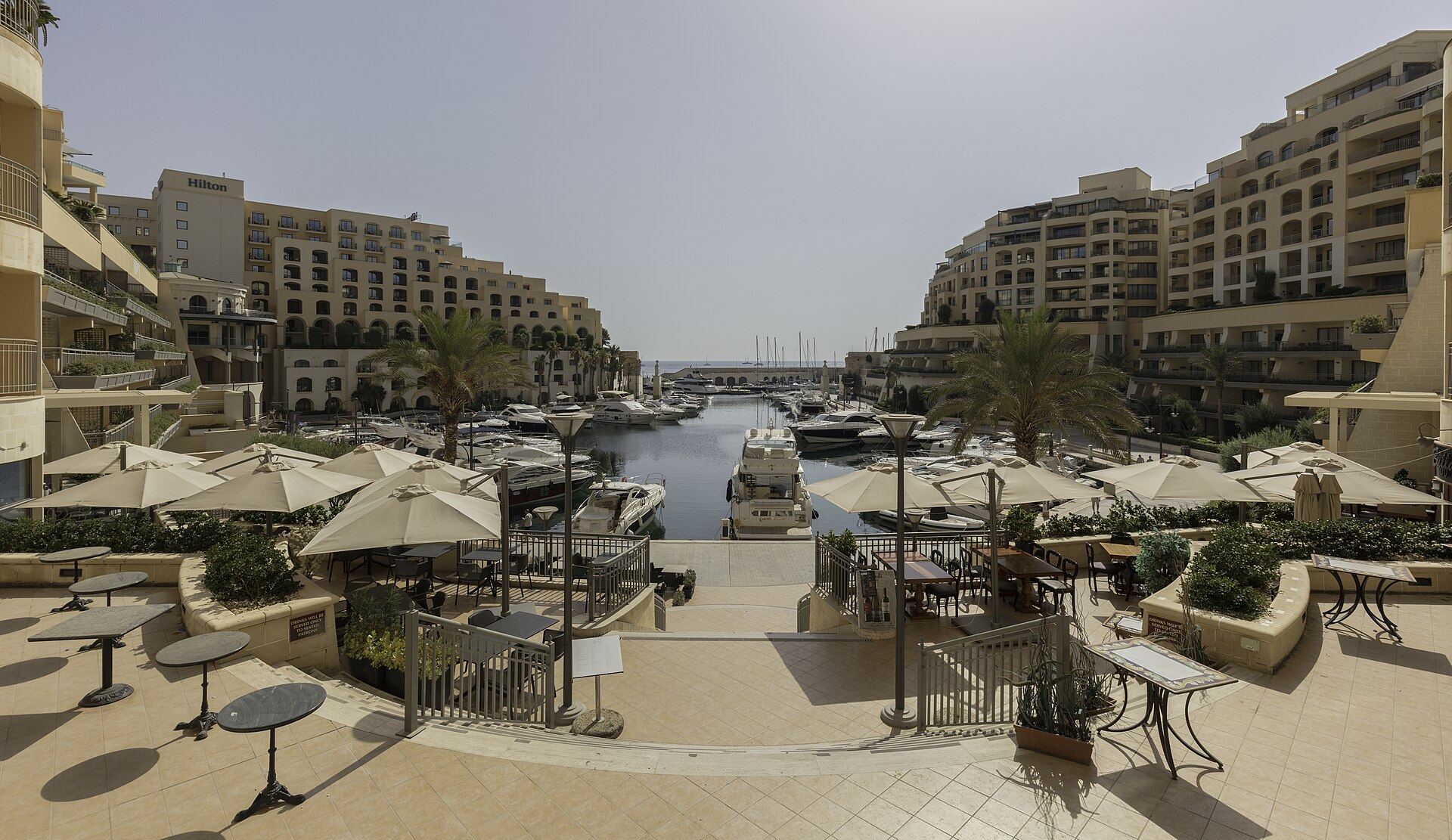 Motor yachts berthed in the Portomaso marina basin at St Julian's, ringed by the marina's apartment blocks and the Portomaso tower.